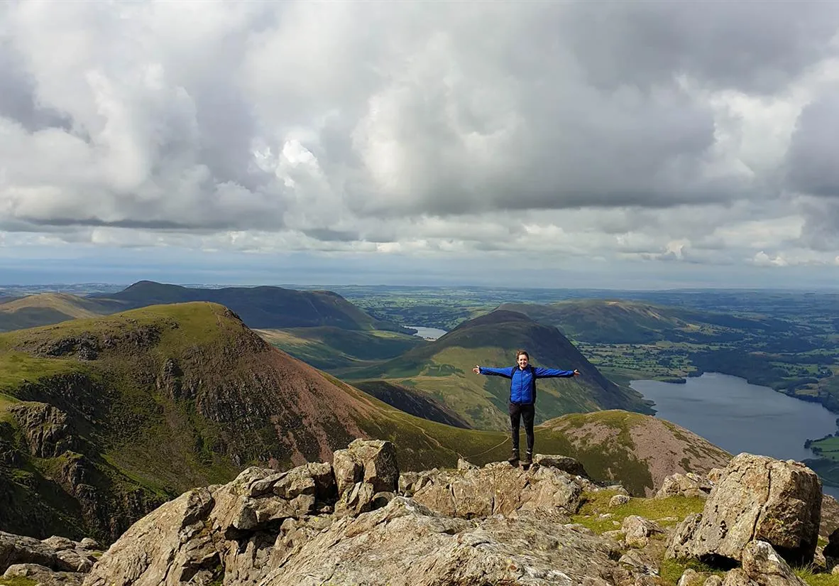 Woman on top of mountain on coast to coast walk