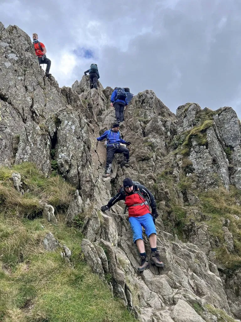 Group hiking up Helvellyn through Striding Edge