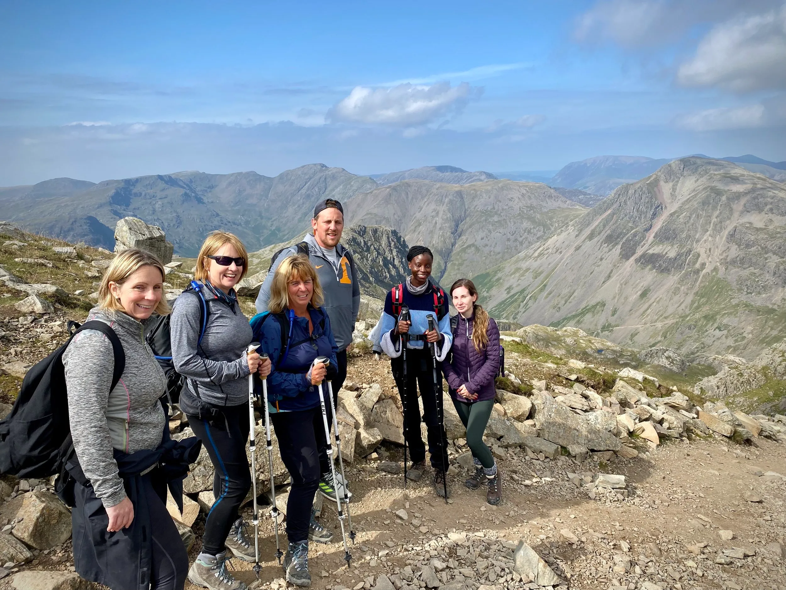 Small group posing for a photo on a mountaintop