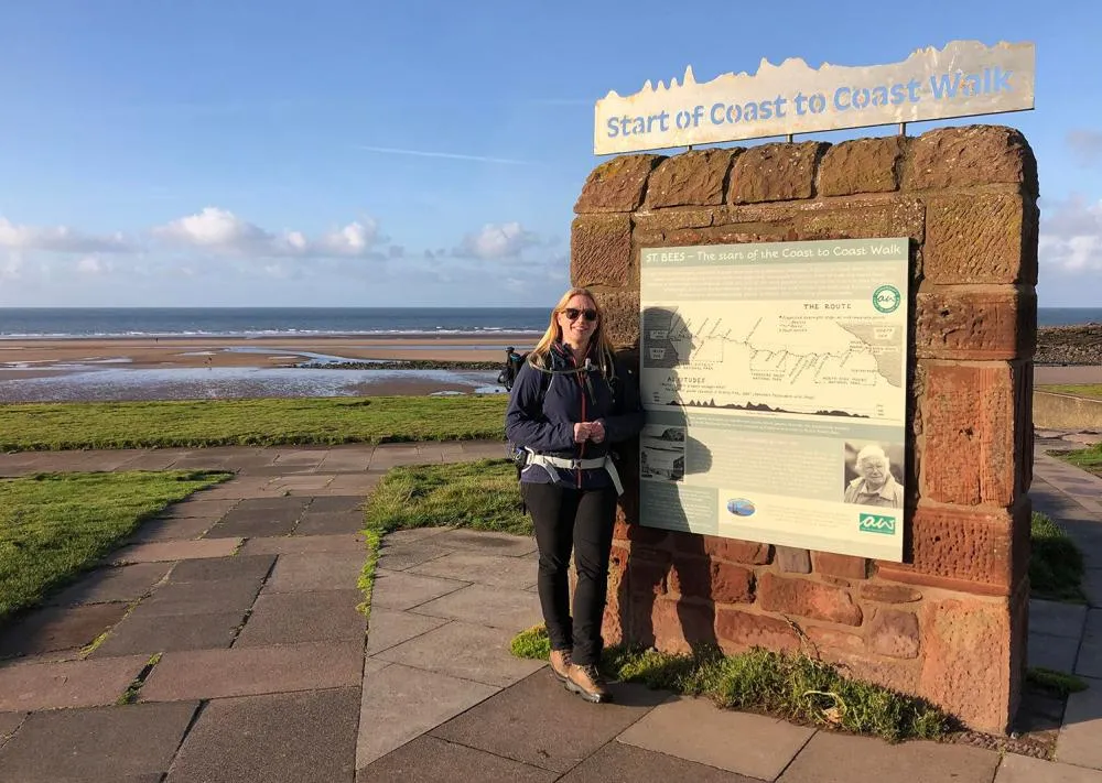 woman in front of Coast to Coast welcome sign