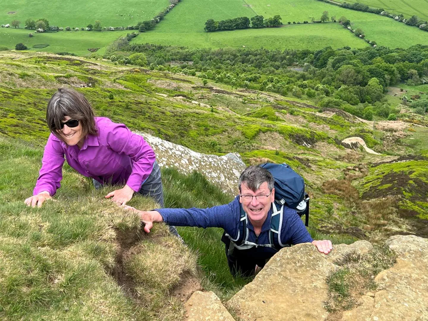 Couple climbing up coast to coast mountainside