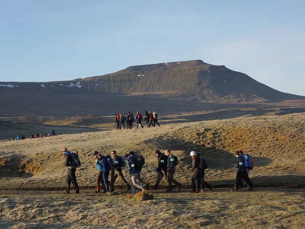 Group walking across yorkshire 3 peaks plain